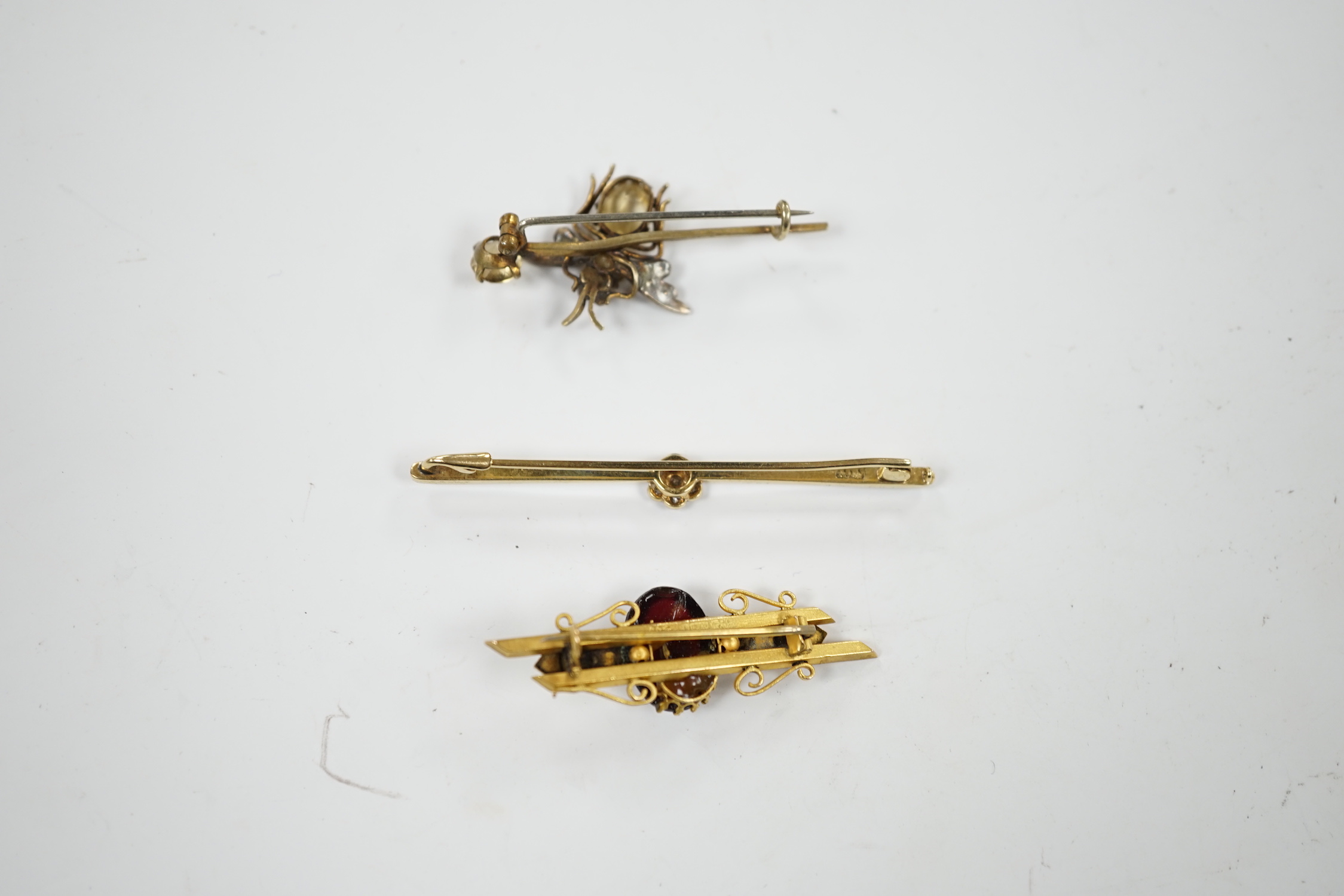 An Edwardian 15ct and diamond cluster set bar brooch, 60mm and two other gem set bar brooches including a bug brooch.